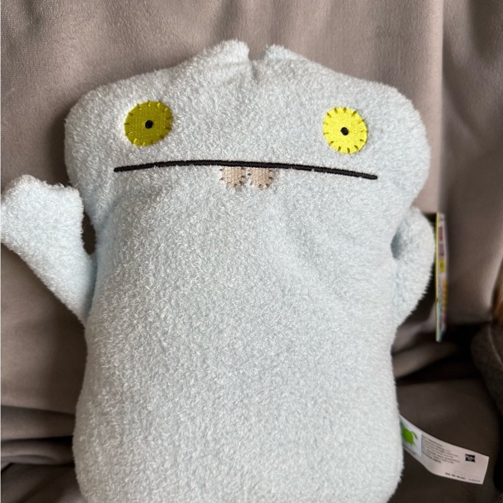 Blue Stuffed Animal with Quirky Mouth and Mismatched Eyes